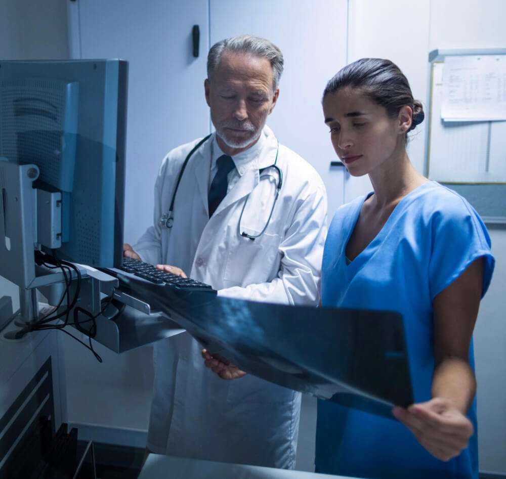 Doctor y enfermera examinando una x-ra