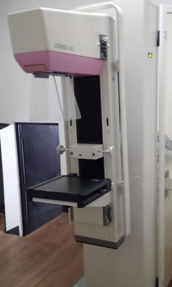 foto vertical de maquina de mamografia en una sala clinica - fisikamedika