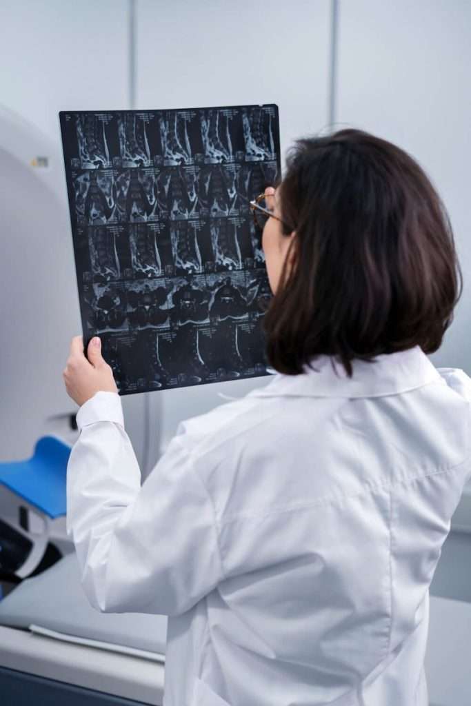 doctora de espaldas revisando la calidad de una imagen de rayos x